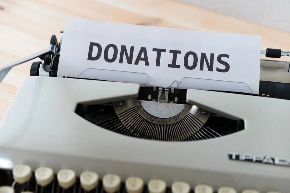 máquina de escribir con un papel que dice 'donations'