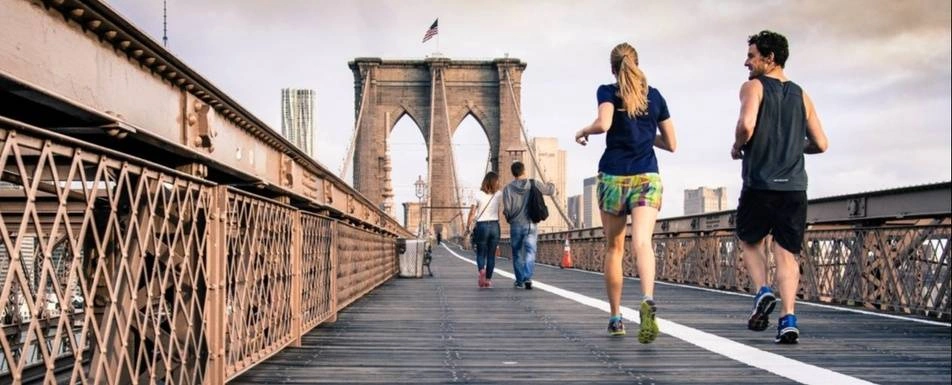 People running and walking on the Brooklyn bridge.