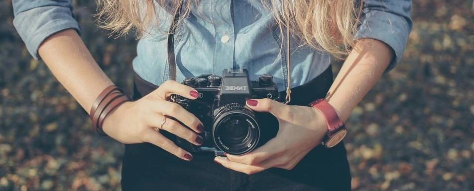 A close up of a woman holding a camera.