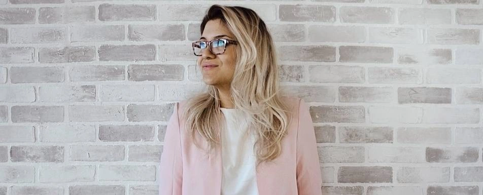 A woman standing in front of a brick wall