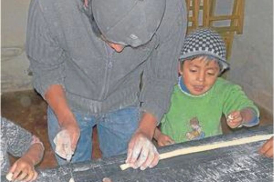 Niño ayudando a su papá en un emprendimiento culinario