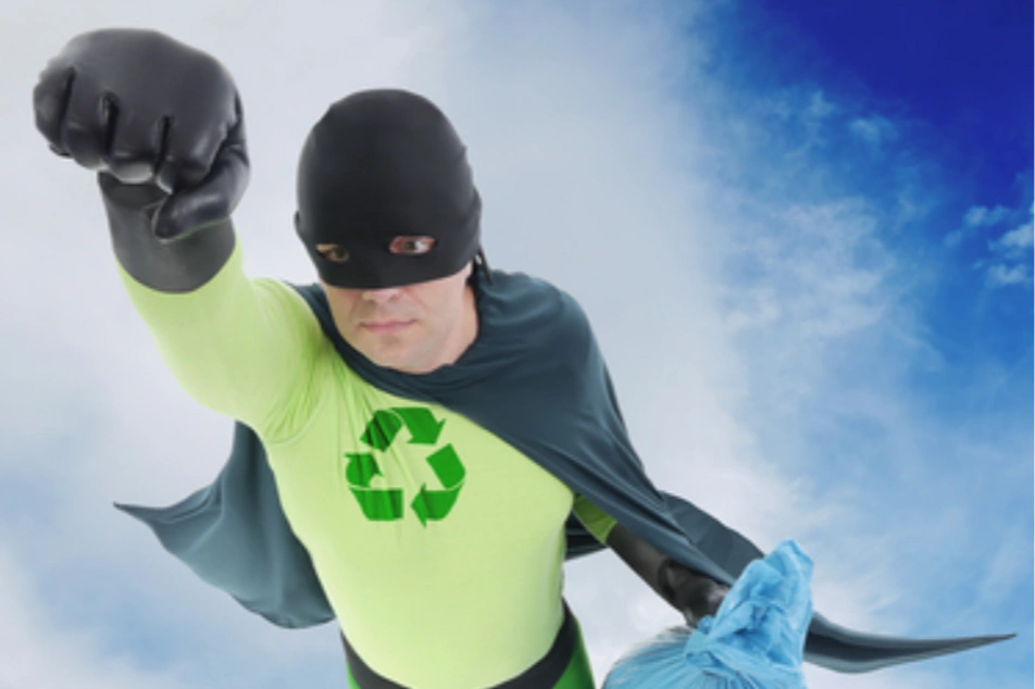 Un hombre disfrazado de super héroe con el signo de reciclaje en el pecho