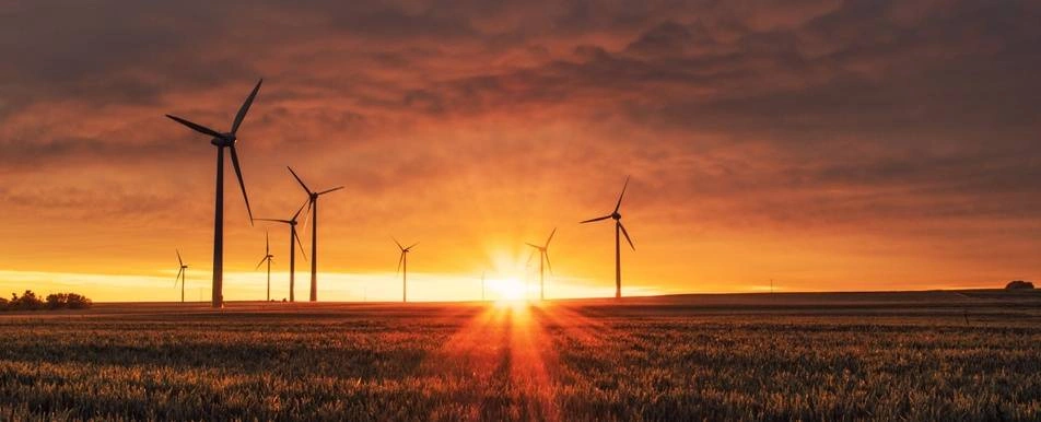 wind turbines against a sunset background