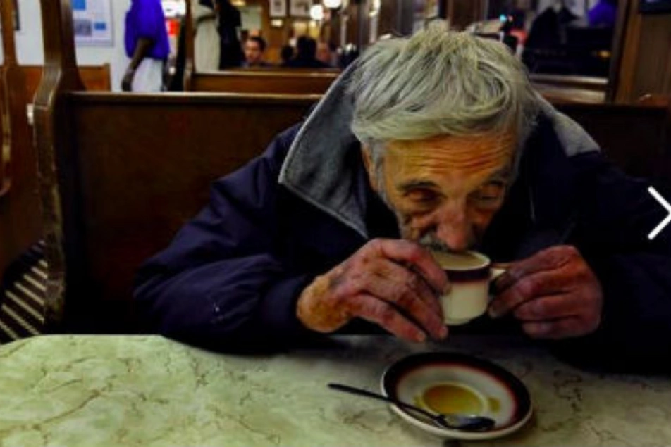 Un viejito tomando un café