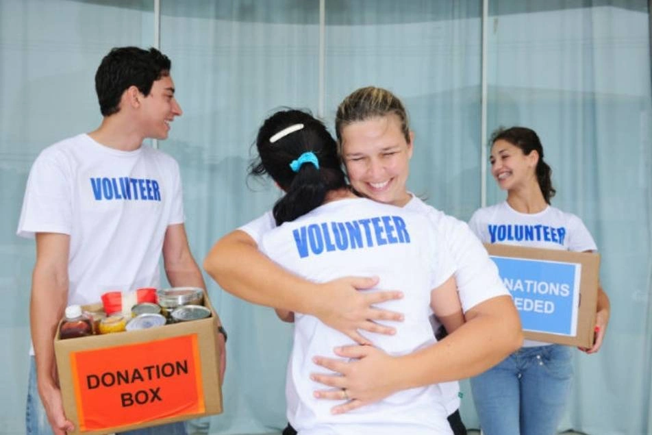 Voluntarios felices, dándose un abrazo