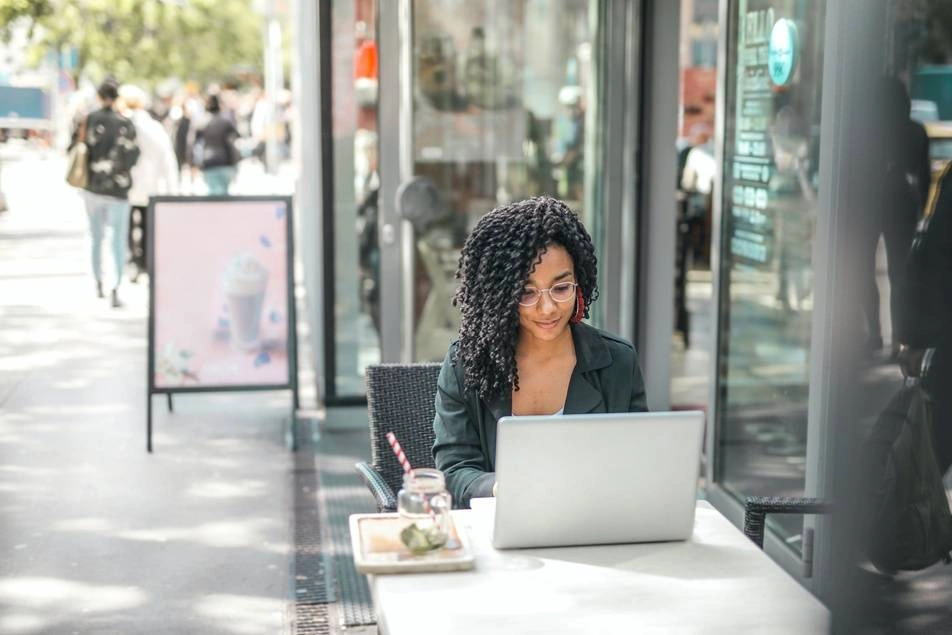 woman on laptop in front of cafe