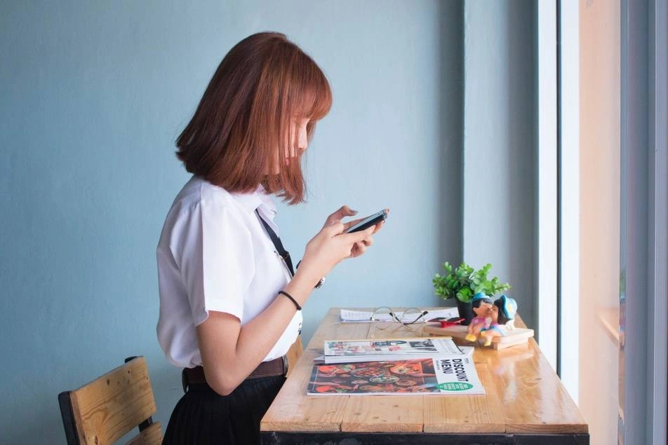 woman looking at phone at table