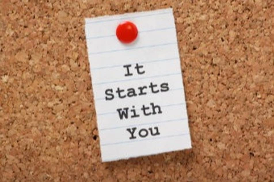 Foto de un pin en un corcho que dice It Starts With You (Comienza por Ti)