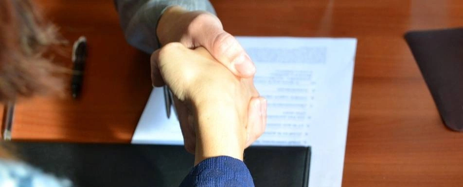 A handshake over a desk.
