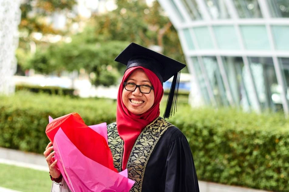 Woman smiling wearing graduation outfit