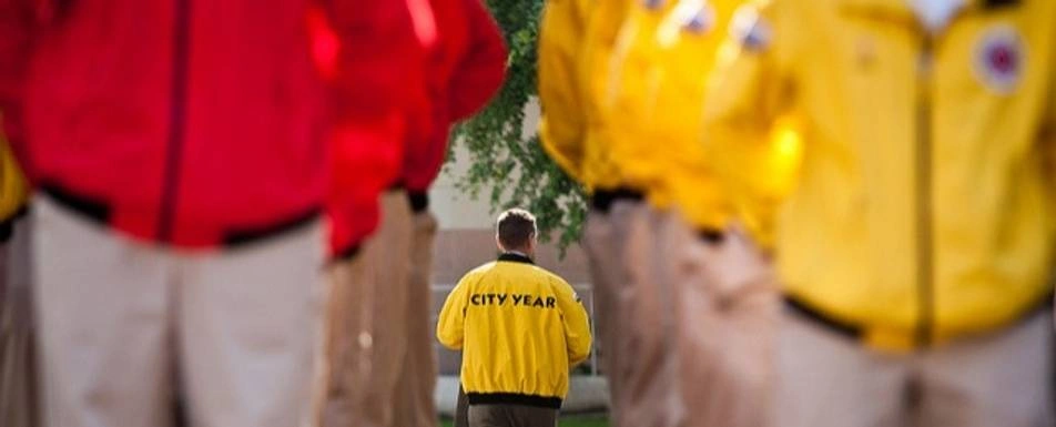 A group of people wearing red and yellow 'City Year' jackets.