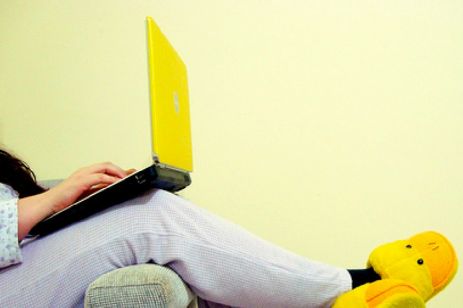 Persona relajada escribiendo en su laptop usando pantuflas