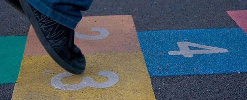 A close up of someone playing hopscotch.