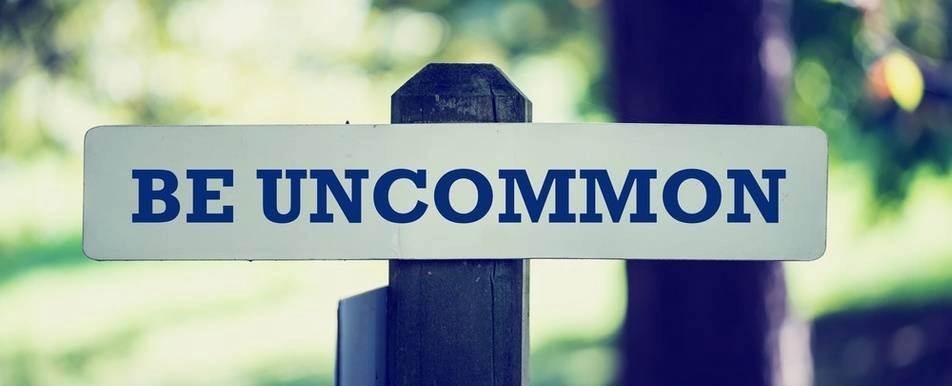 A sign that says be uncommon.