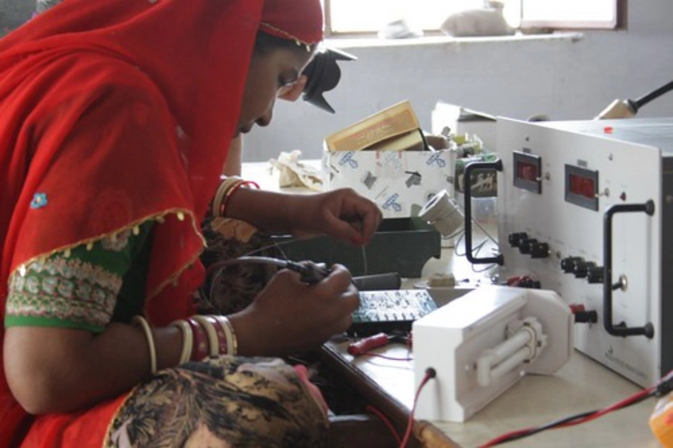 Una mujer india arreglando un equipo electrónico