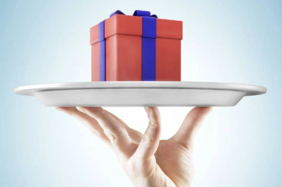 Una mano sosteniendo una bandeja con un regalo