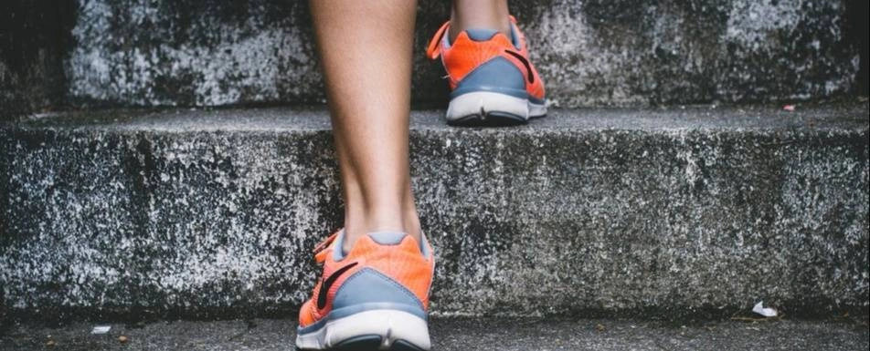 A  shot of a person's sneakers. They are climbing steps.