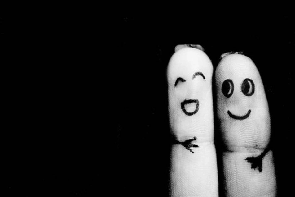 Dos dedos con caras sonrientes dibujadas